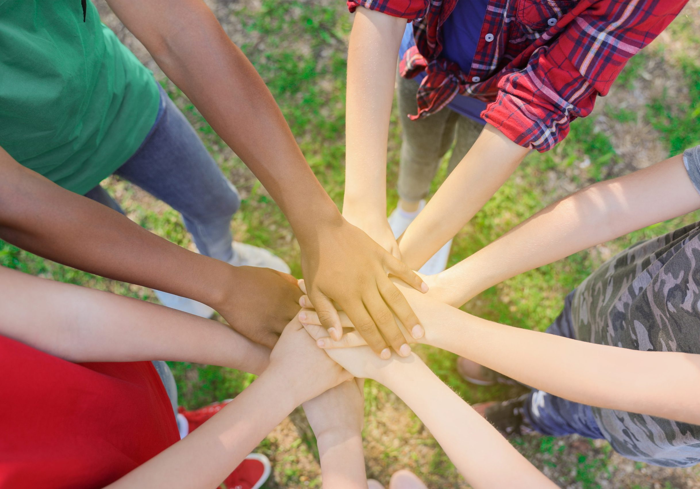 Children of different cultures and races with their hands in the center